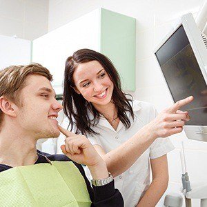 Dentist and patient looking at x-rays planning dental services