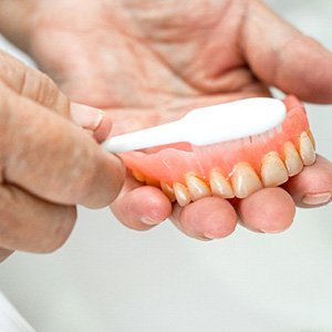 patient brushing their dentures