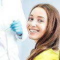 Woman smiling in dental chair for preventive dentistry