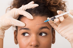 dentist injecting BOTOX in a patient’s forehead
