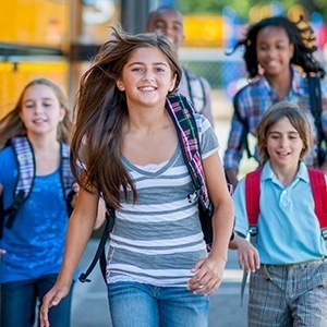 Group of kids getting off of bus with healthy smiles thanks to children's dentistry