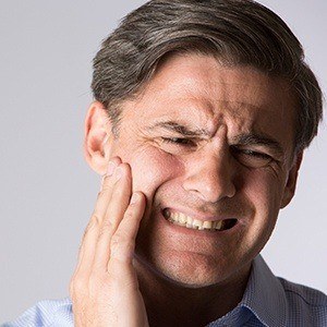 Man holding jaw in pain