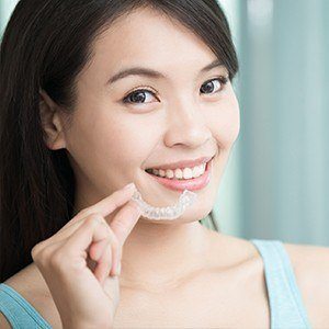 Woman placing Invisalign tray