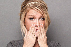 Woman with cracked teeth covering her mouth