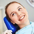 Woman smiling in dental chair during preventive dentistry visit