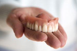 hand holding a full denture