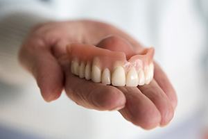 hand holding a full denture