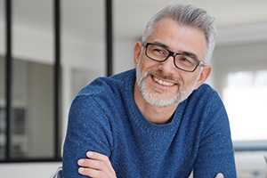 smiling older man in a blue shirt and glasses