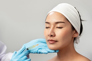 woman closing her eyes and getting dermal fillers