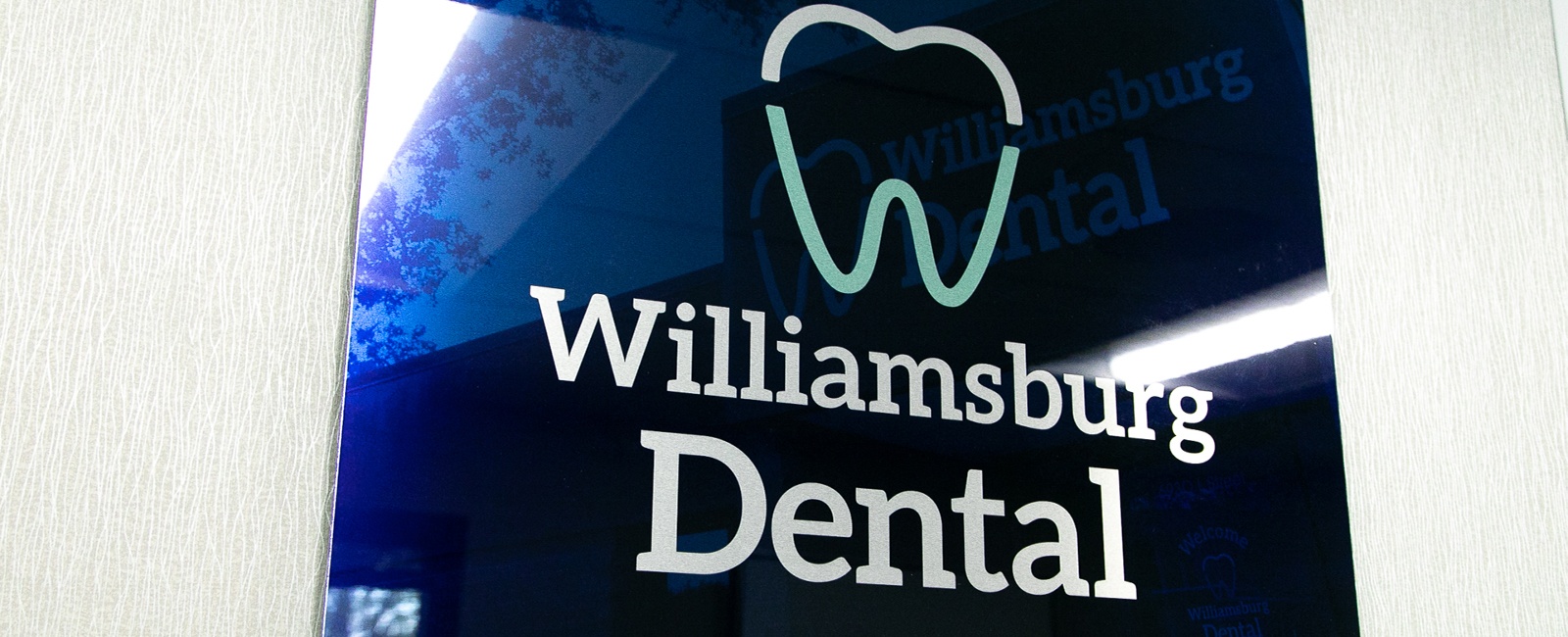Williamsburg Dental logo sign on dental office wall