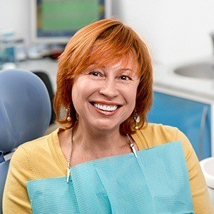 Smiling woman in dental chair after preventive dentistry visit