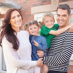 Smiling family outdoors after receiving dental services in East Lincoln