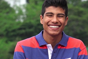 Young man smiling outside after tooth extraction