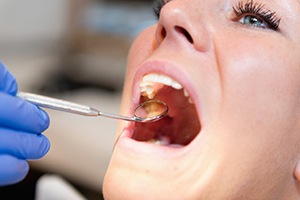 Woman receiving oral exam after tooth extraction