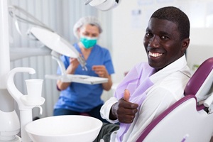 Man smiling and giving thumbs up after dental implant salvage