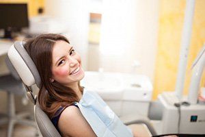 A woman smiling during her Invisalign checkup appointment