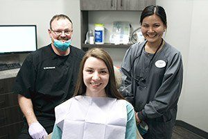 Dentist dental team member and patient in dental treatment room