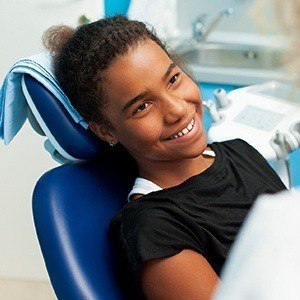 Young girl smiling in dental chair for children's dentistry treatment