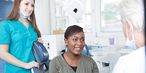 Woman smiling at her Lincoln implant dentist during appointment