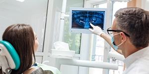 Lincoln dental implant dentist explainin tooth extractions to patient