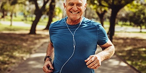 Healthy man with dental implants in Lincoln jogging outside