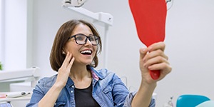 Young woman admiring her new dental implants in Lincoln