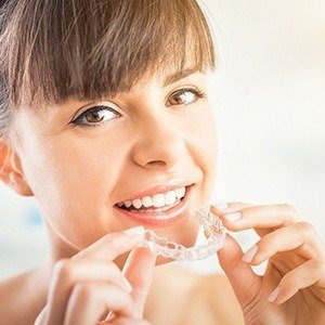 Woman placing Invisalign tray