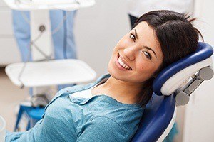 Smiling woman in dental chair after dental checkup and teeth cleaning