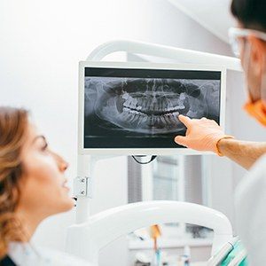 Dentist and patient looking at digital x-rays