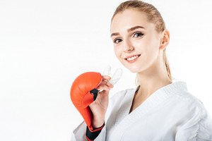 Girl smiling and holding a athletic mouthguard in Lincoln