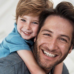 Father and son smiling after children's dentistry visit