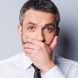 Man with cracked teeth covering mouth