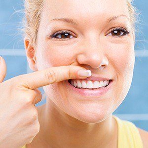 Woman looking at her gums before gum disease treatment