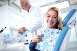 A young female with blonde hair giving a thumbs up after completing her oral cancer screening