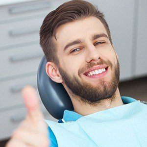 Smiling man in dental chair after preventive dentistry