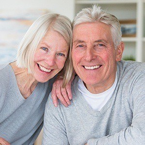 Senior man and woman smiling together after restorative dentistry