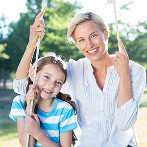 Woman and child smiling after receiving dental services