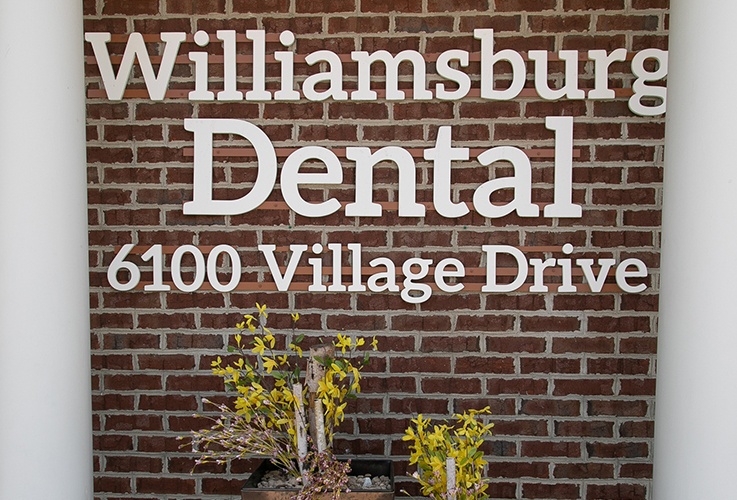 Williamsburg Dental logo on brick wall