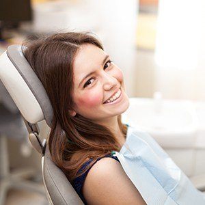 Smiling woman in dental chair for dental services at Williamsburg Dental Village Drive