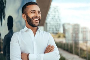 Man in city smiling with arms folded