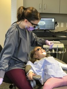 A dentist examining a patient's mouth.