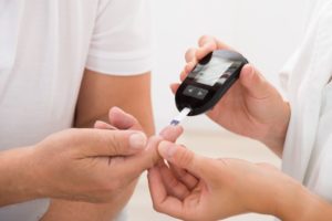 A doctor measuring a patient’s blood sugar.