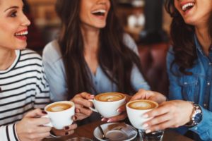 women smiling and drinking coffee