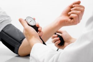 dentist taking a patient’s blood pressure
