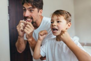 family flossing together teaching about oral health