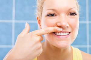 woman looking at her strong gums and preventing gum disease