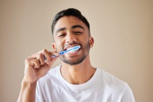 young man brushing his teeth