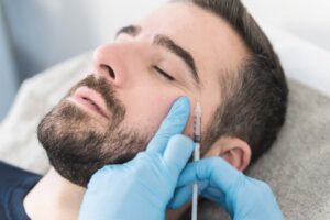man getting a BOTOX injection near his crow’s feet around the eye