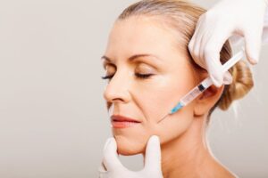older woman getting BOTOX injections by her mouth