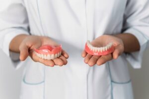 dental professional hands holding dentures